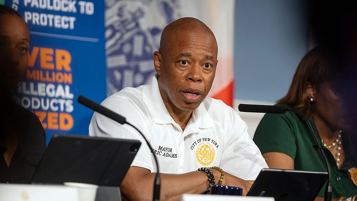 Mayor Eric Adams standing confidently with his arms crossed.
